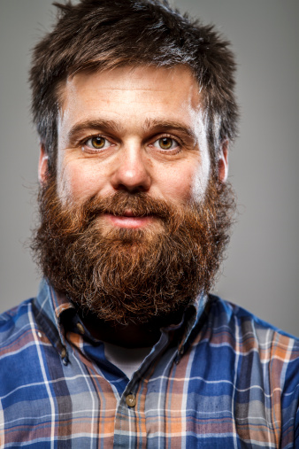 A portrait of a man smiling. He has a long beard. Slight vignette is intentional.