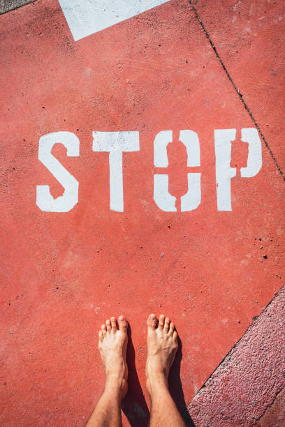 istock An illegal immigrant stands barefoot at a stop sign on the ground. 1713297528