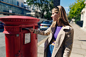Teenage girl sending a postcard from London, United Kingdom