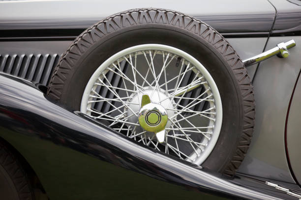Detail of duotone black and grey MG Midget TD British Classic Sports Car with side mounted spare wire spoked wheel on display at a Classic Car Show.
