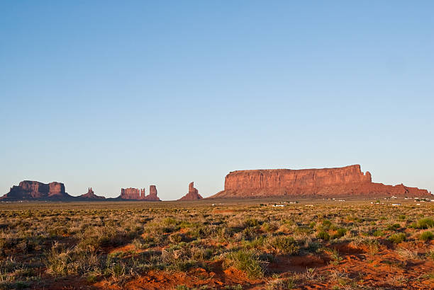Sentinal Mesa in the Evening Light Monument Valley, on the Arizona - Utah border, gives us some of the most iconic and enduring images of the American Southwest. The harsh empty desert is punctuated by many colorful sandstone rock formations. It can be a photographer's dream to capture the ever-changing play of light on the buttes and mesas. Even to the first-time visitor, Monument Valley will probably seem very familiar. This rugged landscape has achieved fame in the movies, advertising and brochures. It has been filmed and photographed countless times over the years. If a movie producer was looking for a landscape that epitomizes the Old West, a better location could not be found. This picture of the rock formations in the evening light was photographed from the Monument Valley Road north of Kayenta, Arizona, USA. jeff goulden monument valley stock pictures, royalty-free photos & images