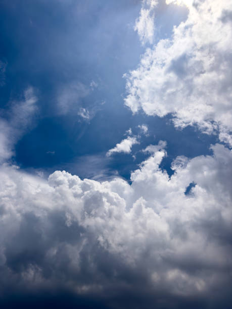 istock White clouds rising up and flowing in the blue sky, shining under the sun light. Vertical. Cloudscape, Japan 1713308928