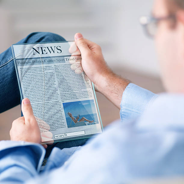 człowiek czytanie wiadomości na futurystyczny tablet - newspaper the media reading digital display zdjęcia i obrazy z banku zdjęć