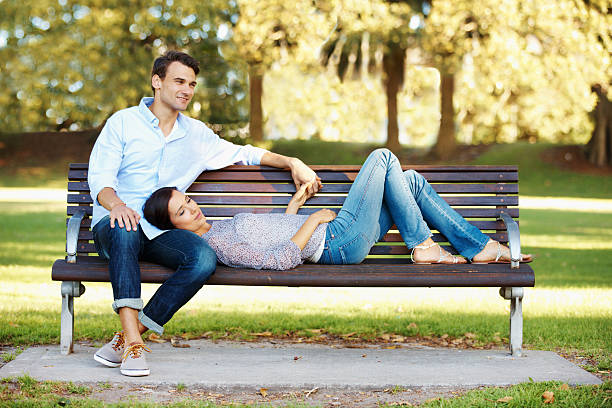 Couple sitting on bench at sunset time
