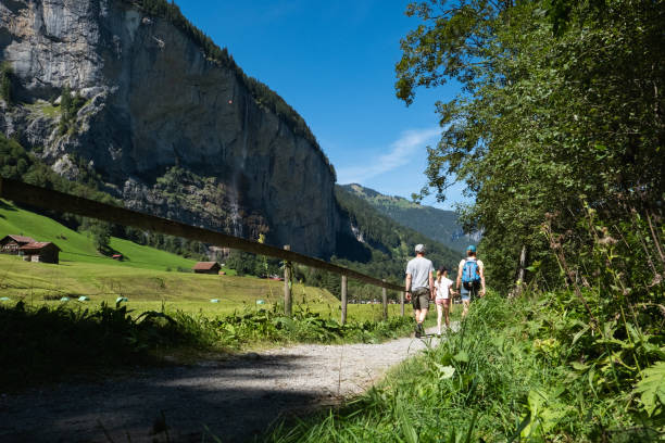 A family enjoys walking through the beautiful village of Lauterbrunnen in Switzerland. Family exploring the small villages in and around Europe while on vacation