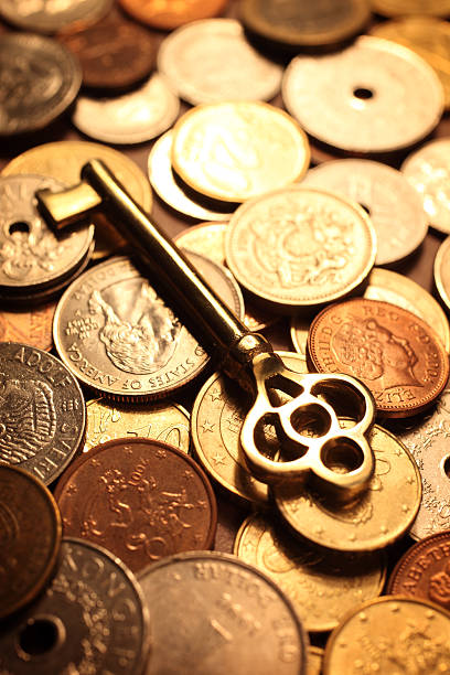 złoty stary klucz na stos monet - aspirations business skeleton key key zdjęcia i obrazy z banku zdjęć