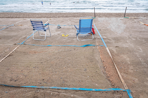 An empty Mediterranean beach with space separations during the summer of 2020 with the new normality after the pandemic.