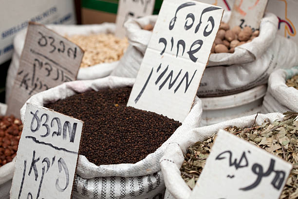 Sacks of spices, herbs and nuts  at market in old Arce city. Selective focus on sack of black pepper.