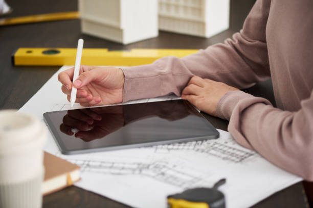 istock Hand of young female engineer or architect in blue pullover holding stylus 1713326512