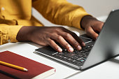 Hands of young male solopreneur pressing buttons of laptop keyboard