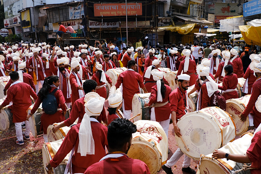 Pune, India - September 29, 2023, Ganesh immersion procession, Dhol tasha pathak playing traditional dhol on the streets of pune on the occasion of Ganpati visarjan festival in maharashtrian attire.
