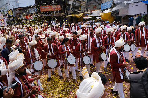 Pune, India - September 29, 2023, Ganesh immersion procession, Dhol tasha pathak playing traditional dhol on the streets of pune on the occasion of Ganpati visarjan festival in maharashtrian attire.