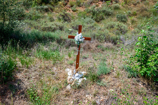 A cross from a grave in a burial ground in a rural mountain area.
