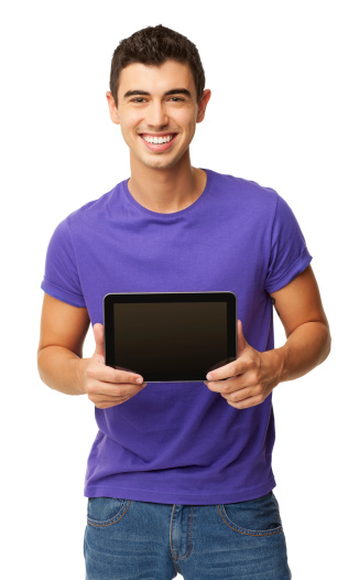 Portrait of happy young boy in casual wear holding digital tablet with blank screen. Vertical shot. Isolated on white.