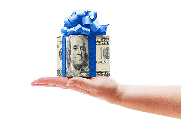 hand holding geld, bargeld mit blue geschenk-schleife auf weißen - currency giving wealth human hand stock-fotos und bilder