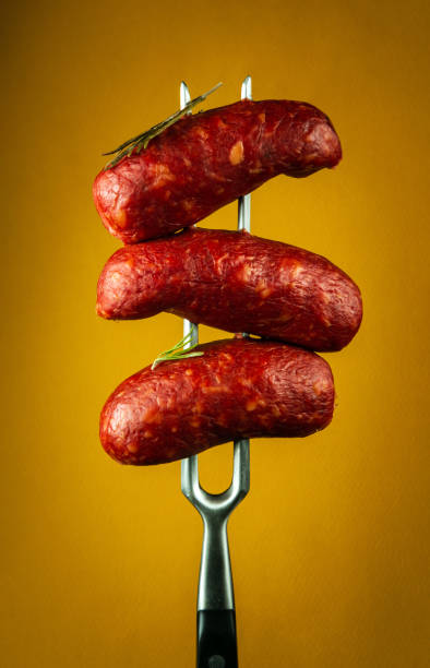 istock Fried hot sausages with beef on a fork. Delicious lunch concept for hotel or restaurant on yellow background 1713337123