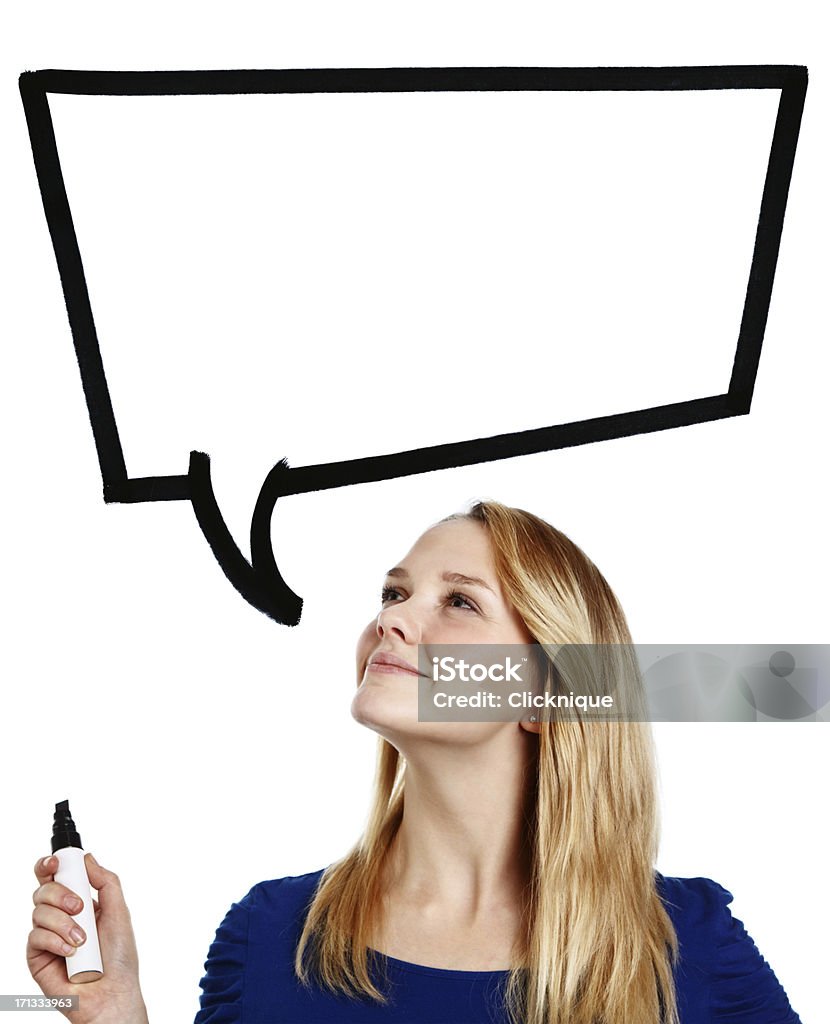 Confident, smiling blonde teenager looks up at hand-drawn speech bubble "A pretty blonde teenager holding a pen looks up smiling confidently at the hand-drawn cartoon-style speech bubble above her,blank and ready for your message." Adolescence Stock Photo