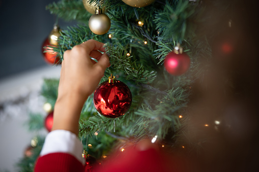 Close-up on a woman decorating the Christmas tree - holiday season concepts