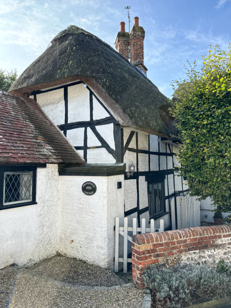 Thatched medieval cottage in West Meon village street in Hampshire, England, UK. Sunny autumn West Meon village street view in Hampshire, England, UK petersfield stock pictures, royalty-free photos & images