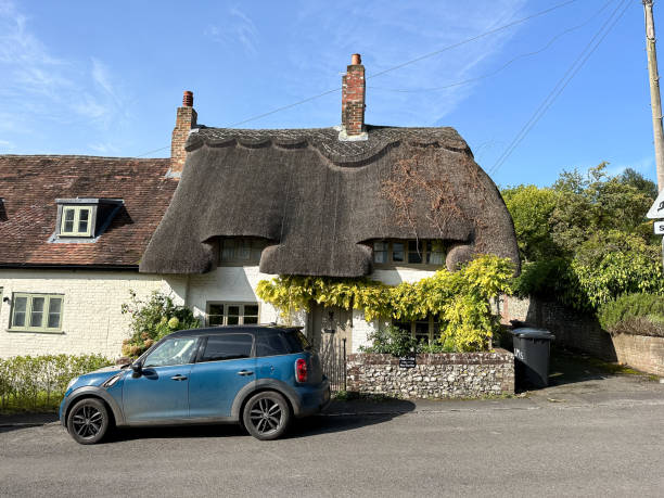 Thatched medieval cottage in West Meon village street in Hampshire, England, UK. Sunny autumn West Meon village street view in Hampshire, England, UK petersfield stock pictures, royalty-free photos & images