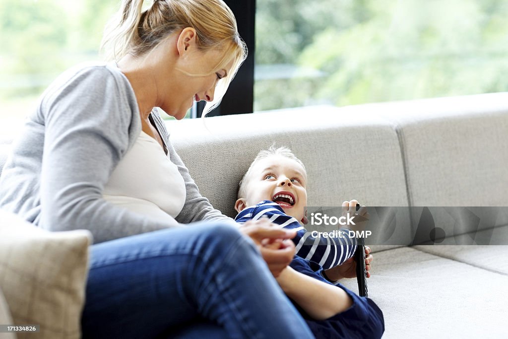 Mujer joven jugando con su hijo en casa - Foto de stock de 20-24 años libre de derechos