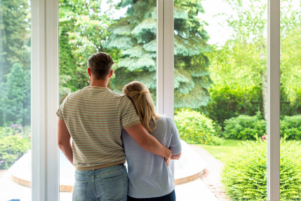istock A couple standing at the window at home and looking out 1713348355