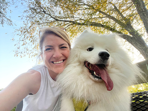 Woman and her Samoyed posing during their run.