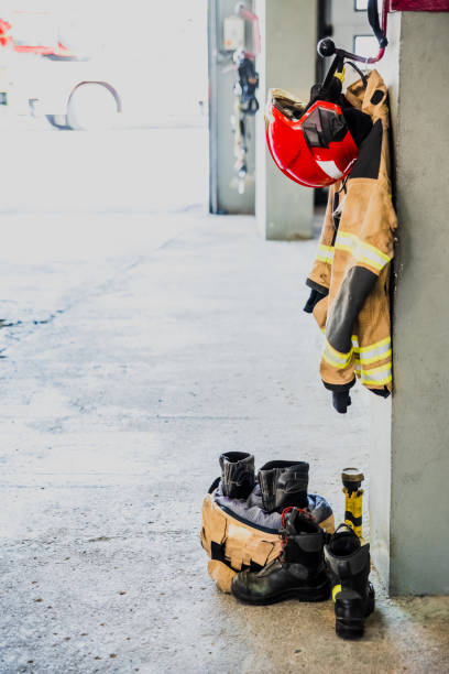istock Boots and fireman's jacket on the garage floor of a fire station. 1713352570