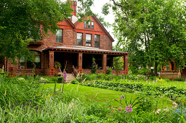 Photo of an American red brick colonial-style suburban home with large circular driveway