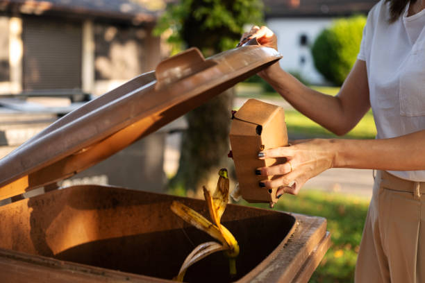 istock A woman throwing food scraps into a biodegradable trash bin. 1713356687