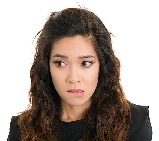 istock Nervous Young Woman Bites Lip And Looks Sideways 171335931