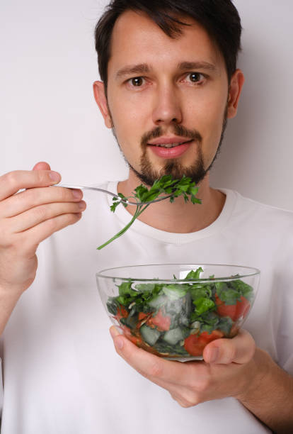 istock Portrait of a man eating figs on a white background 1713364329
