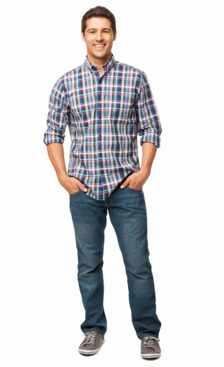 Full length portrait of a handsome young man standing with hands in pockets. Vertical shot. Isolated on white.