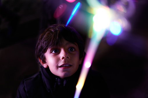 Amazed boy looking at christmas lights at night
