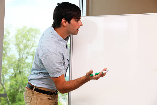 istock young adult presenter is surprised at whiteboard 171336639