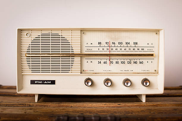 Vintage Beige Radio Sitting on Wood Table "Close up, slightly desaturated, color image of a vintage beige radio sitting on a wood table." bakelite stock pictures, royalty-free photos & images