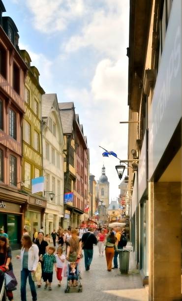 Rue du Gros Horloge Shoppers "Rouen, France - June 2, 2012: Families and tourist shop and celebrate the feast day of St. Joan of Arc along the Rue du Gros Horloge in Rouen,France." rue du gros horloge photos stock pictures, royalty-free photos & images