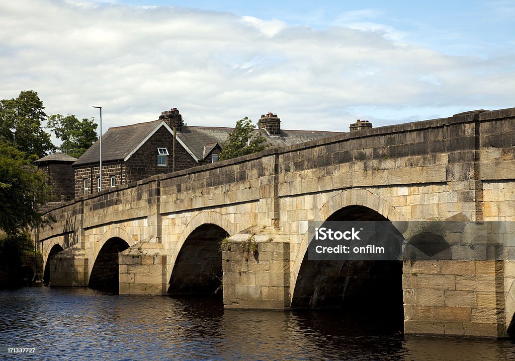 Medieval bridge "Otley Bridge in Otley, West Yorkshire, UK. The bridge is one of the oldest in the UK, built in 1288, although this has been a crossing point over the River Wharfe since pre-Roman times. The bridge is constructed from local millstone grit." Otley Stock Photo