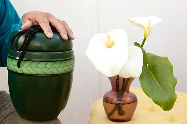Cremation box and flowers in a vase