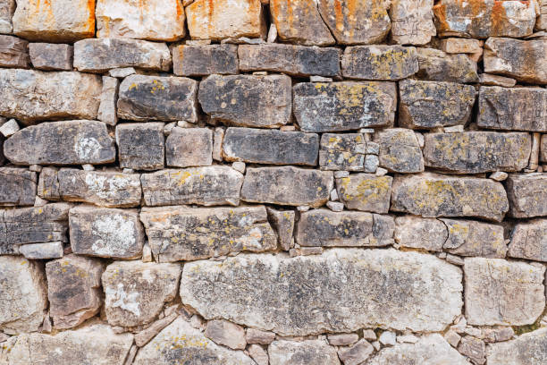 istock Wall of thick ancient rocks, rustic background of medieval construction. 1713391522