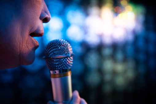 Closeup of an old woman's mouth doing karaoke