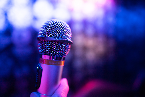 Close-up of an old woman singing karaoke