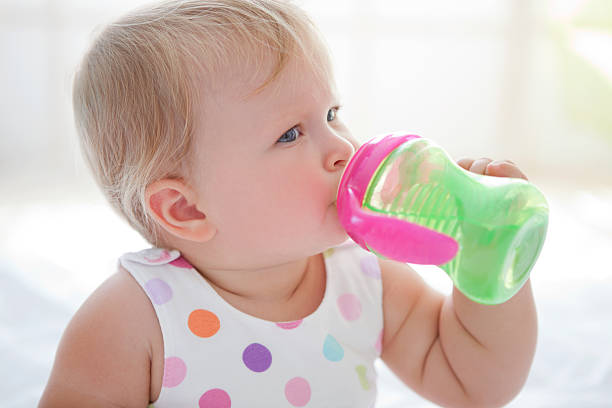 mignon bébé de l'eau potable. - un seul bébé fille photos et images de collection