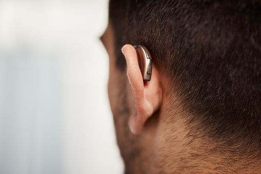 Closeup of hearing aid, ear and man with disability from the back for medical support, listening or healthcare at mockup space. Deaf patient, face and audiology implant to help volume of sound waves