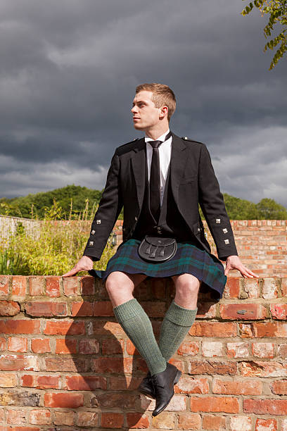 istock Scotsman sitting on brick wall wearing a kilt. 171340351