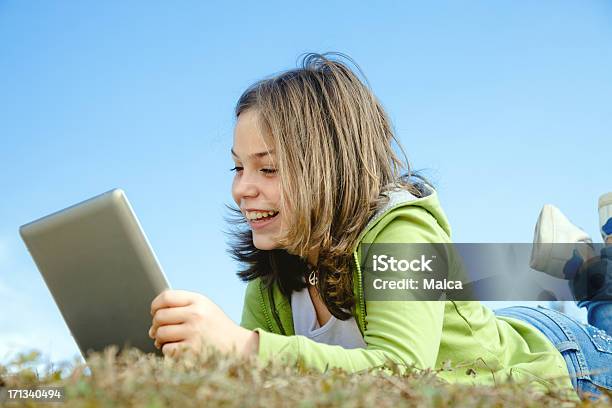 Hijo Usando Tableta Digital Al Aire Libre Foto de stock y más banco de imágenes de 10-11 años - 10-11 años, Acostado, Acostado boca abajo