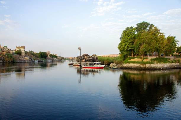 istock a boat sits in the water next to a wall and tree 1713409568