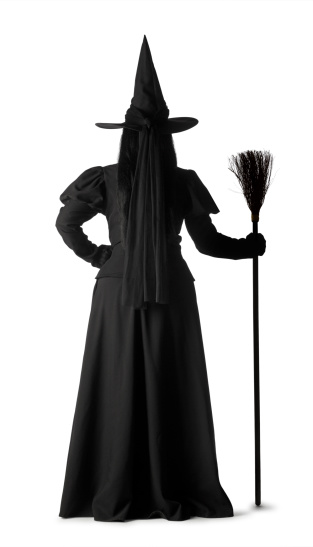 A rear view of a witch with her broomstick.
