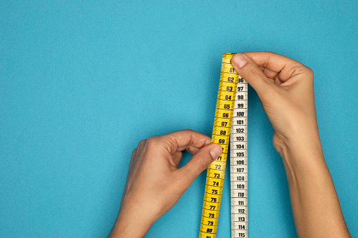 Woman holding tape measure.