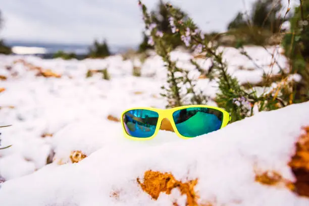 Sports sunglasses are important to protect the eyes in the snow, object on the snowy ground of the mountain.